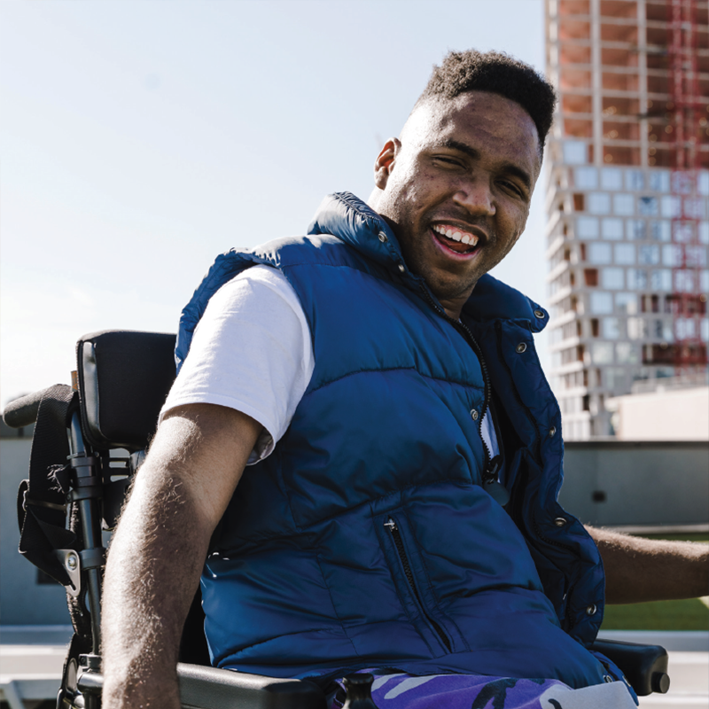 man in wheelchair smiling in an outdoor setting